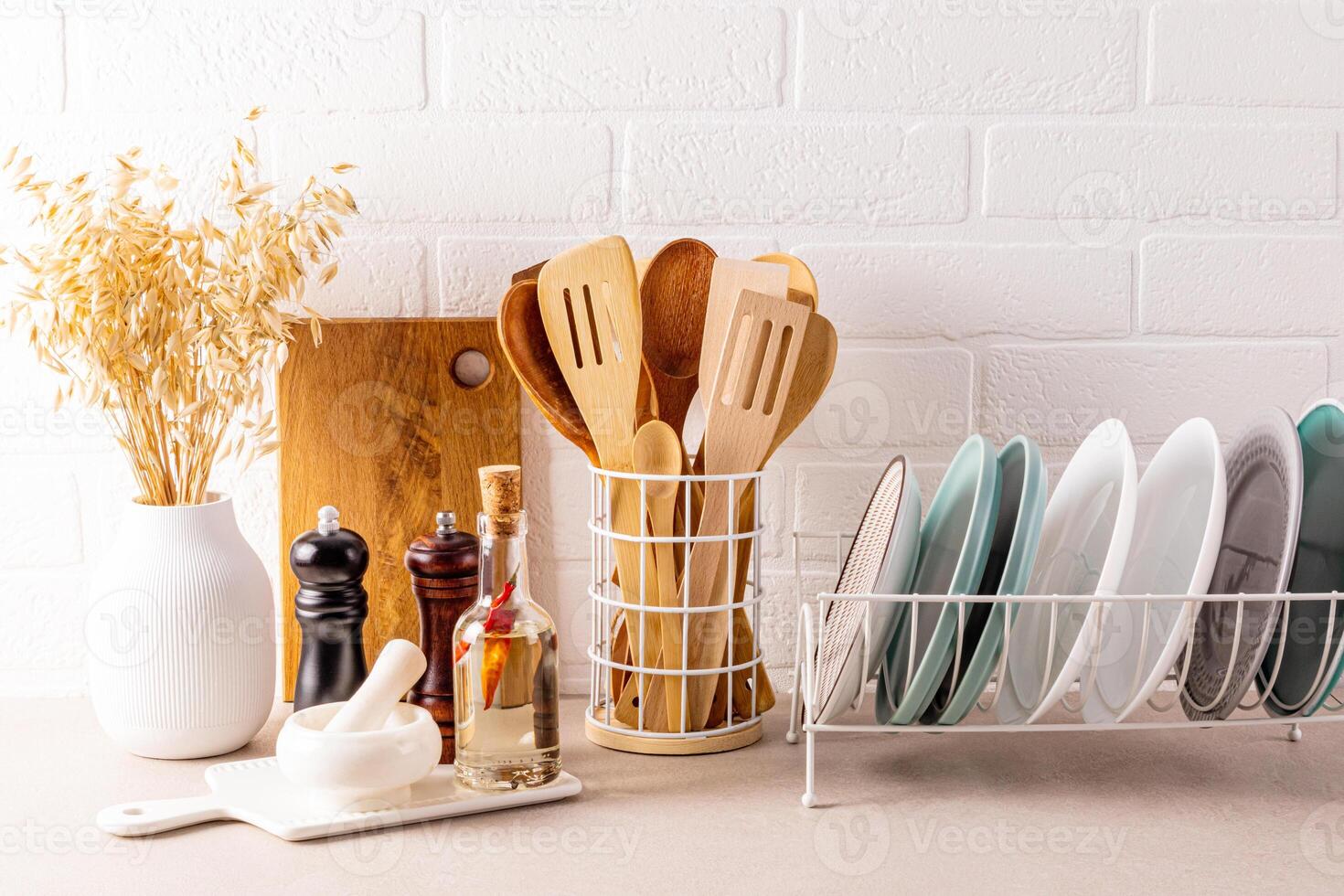 Beautiful kitchen background modern kitchen countertop with a set of kitchen utensils, plate dryer, decorative elements. Front view. Brick white wall. photo