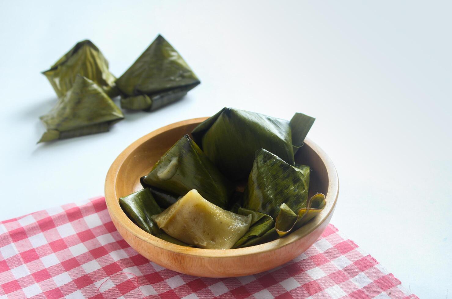 Bugis cake, traditional Indonesian food in the form of cake made from sticky rice flour filled with sweet grated coconut and wrapped in banana leaves. photo