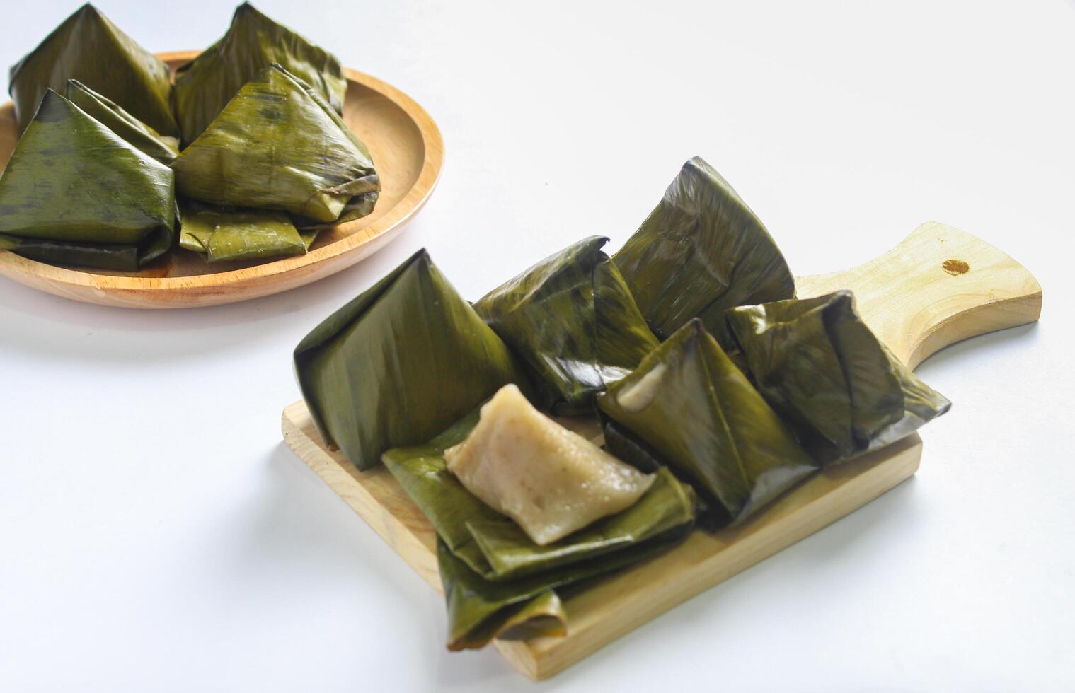 Bugis cake, traditional Indonesian food in the form of cake made from sticky rice flour filled with sweet grated coconut and wrapped in banana leaves. photo