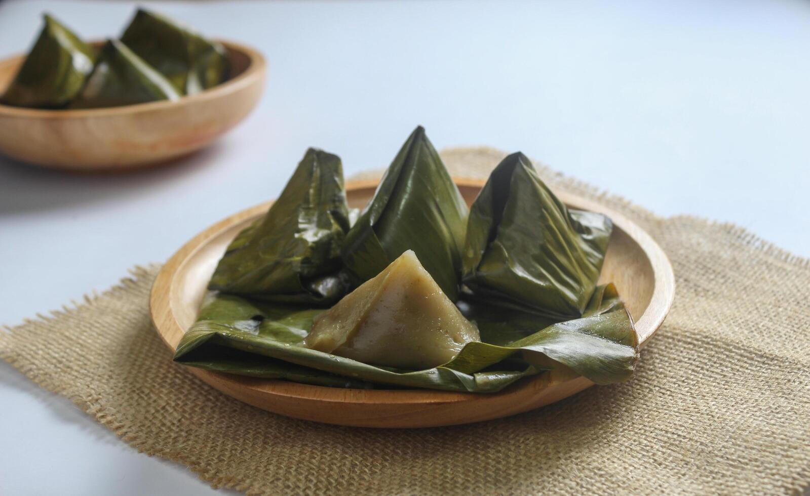 Bugis cake, traditional Indonesian food in the form of cake made from sticky rice flour filled with sweet grated coconut and wrapped in banana leaves. photo