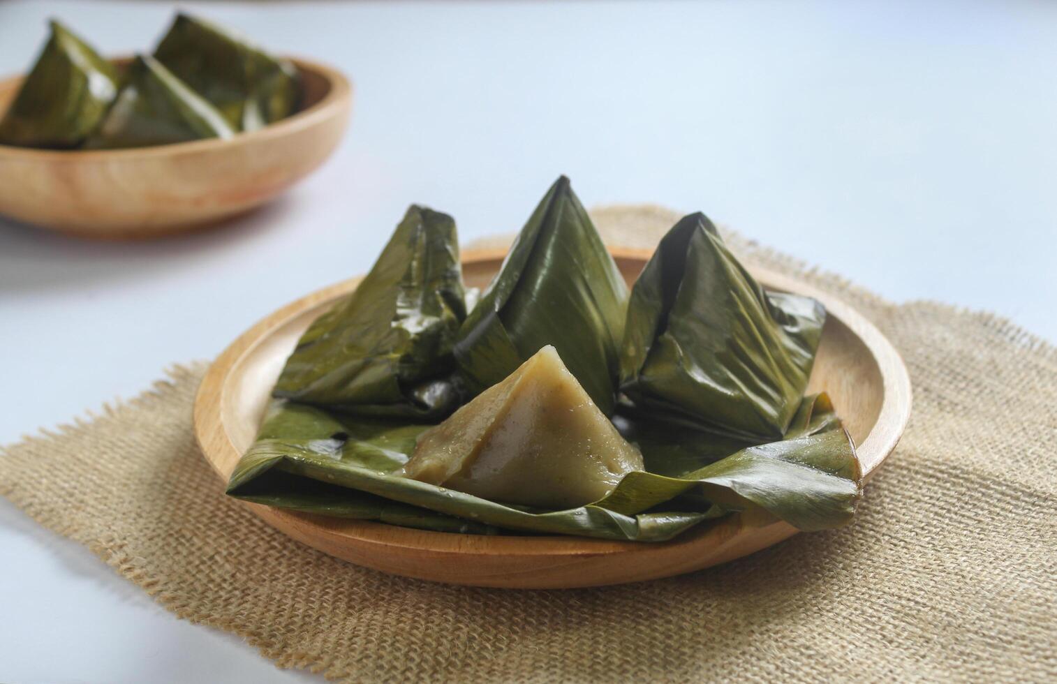 Bugis cake, traditional Indonesian food in the form of cake made from sticky rice flour filled with sweet grated coconut and wrapped in banana leaves. photo