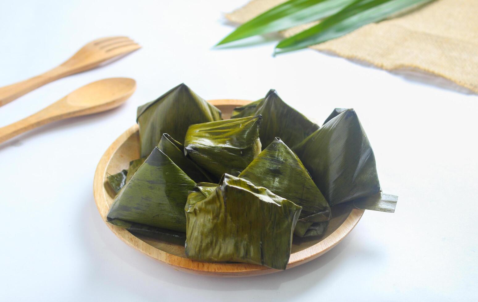 Bugis cake, traditional Indonesian food in the form of cake made from sticky rice flour filled with sweet grated coconut and wrapped in banana leaves. photo