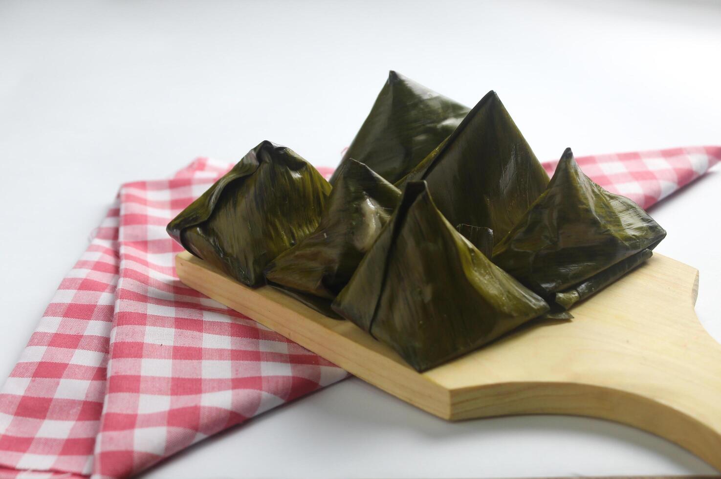 Bugis cake, traditional Indonesian food in the form of cake made from sticky rice flour filled with sweet grated coconut and wrapped in banana leaves. photo