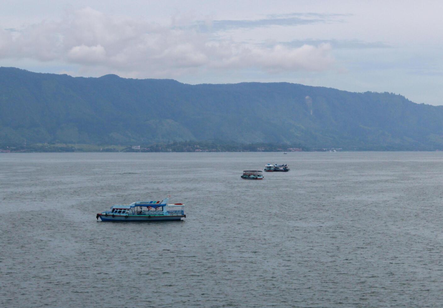 Lake Toba tourist boat sails on the waters of Lake Toba towards Samosir Island photo