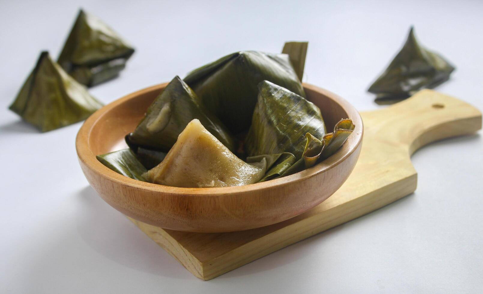 Bugis cake, traditional Indonesian food in the form of cake made from sticky rice flour filled with sweet grated coconut and wrapped in banana leaves. photo