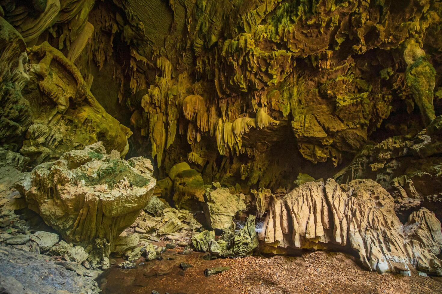The beautiful views of the stalactite and stalagmite-filled cave in Lam Khlong Ngu National Park, Thailand. At the cave's exit is a small waterfall also. photo