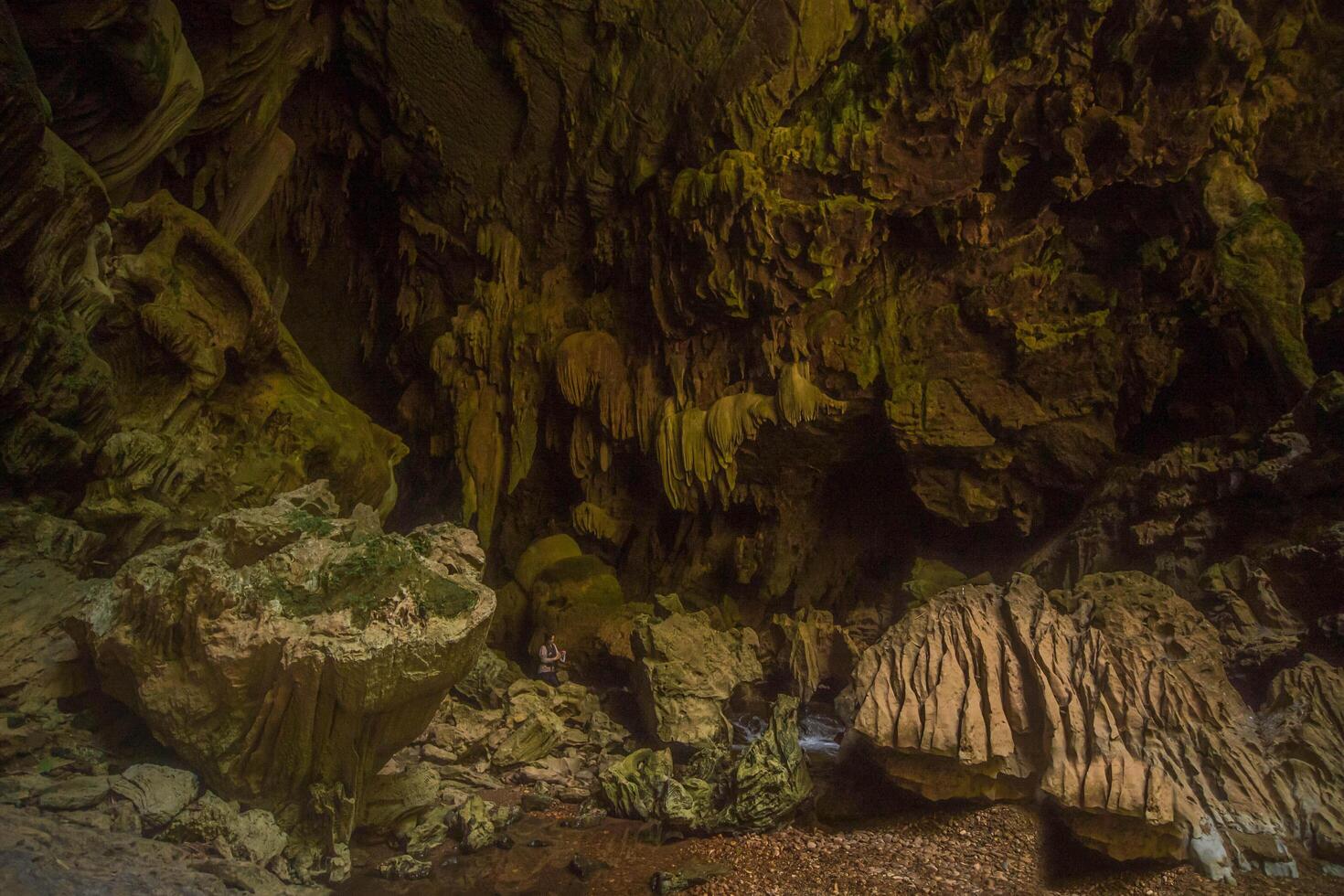 The beautiful views of the stalactite and stalagmite-filled cave in Lam Khlong Ngu National Park, Thailand. At the cave's exit is a small waterfall also. photo