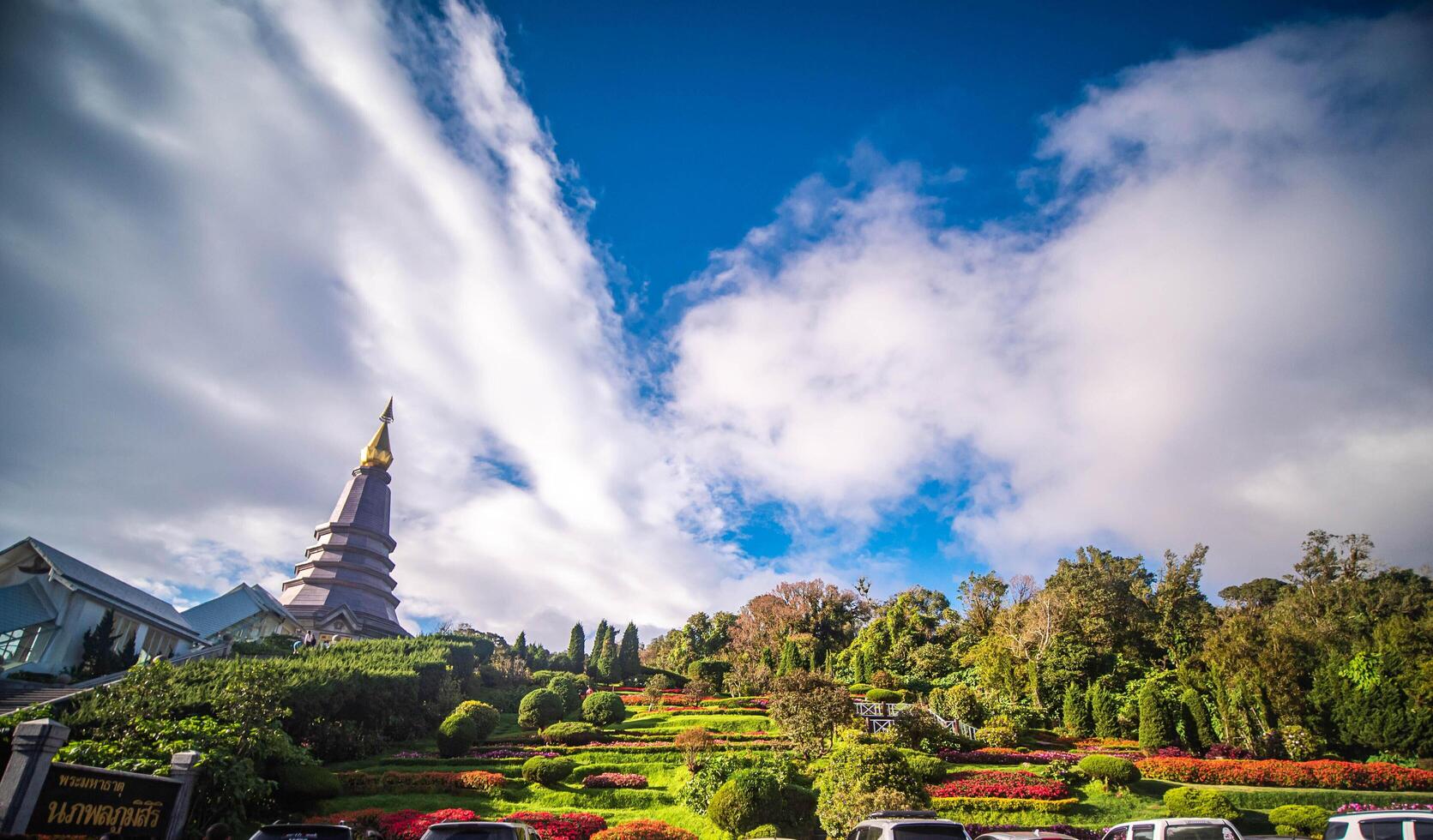 Golden Buddhist temple in Thailand with ancient pagoda and towering architecture against a clear sky, Chaingmai, Thailand. photo