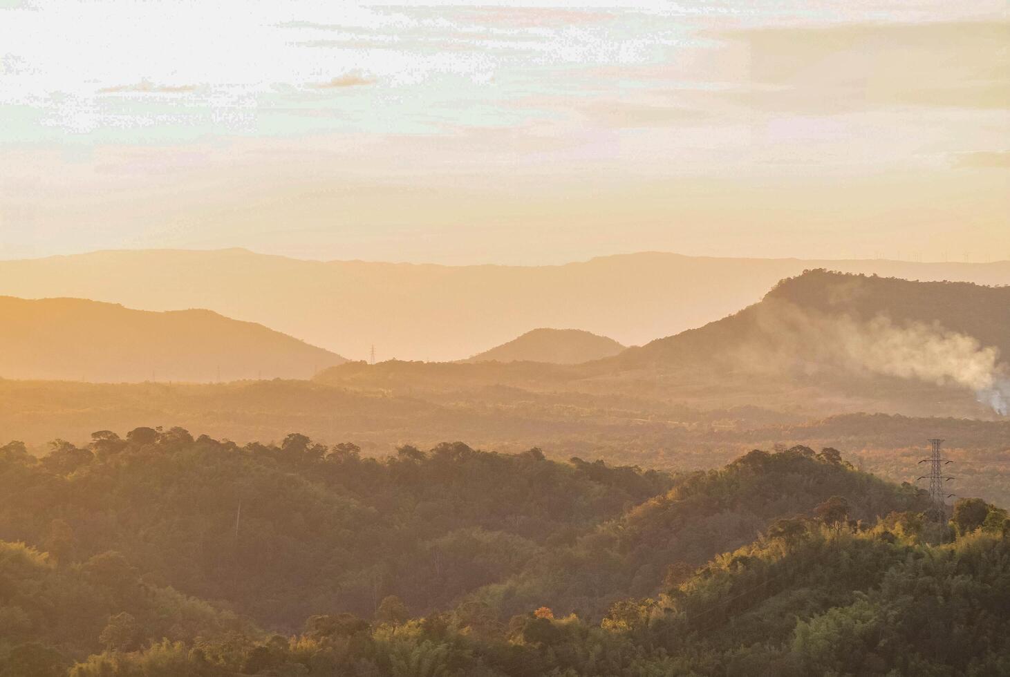 The stunning view from a tourist's standpoint as they go down a hill on a foggy trail with a hill and a background of a golden sky in Forest Park, Thailand. Rainforest. Bird's eye view. Aerial view. photo