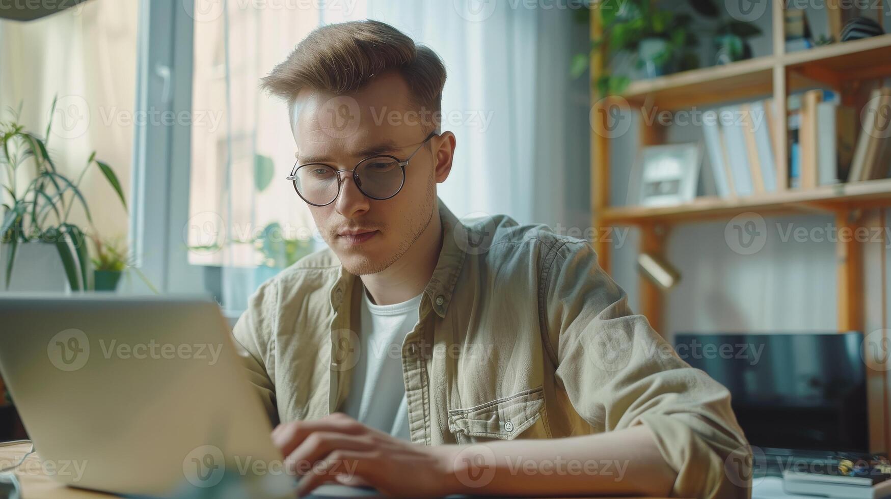 Young German Man Working on Laptop at Home Office, Focused and Productive, Contemporary Workspace with Natural Light photo