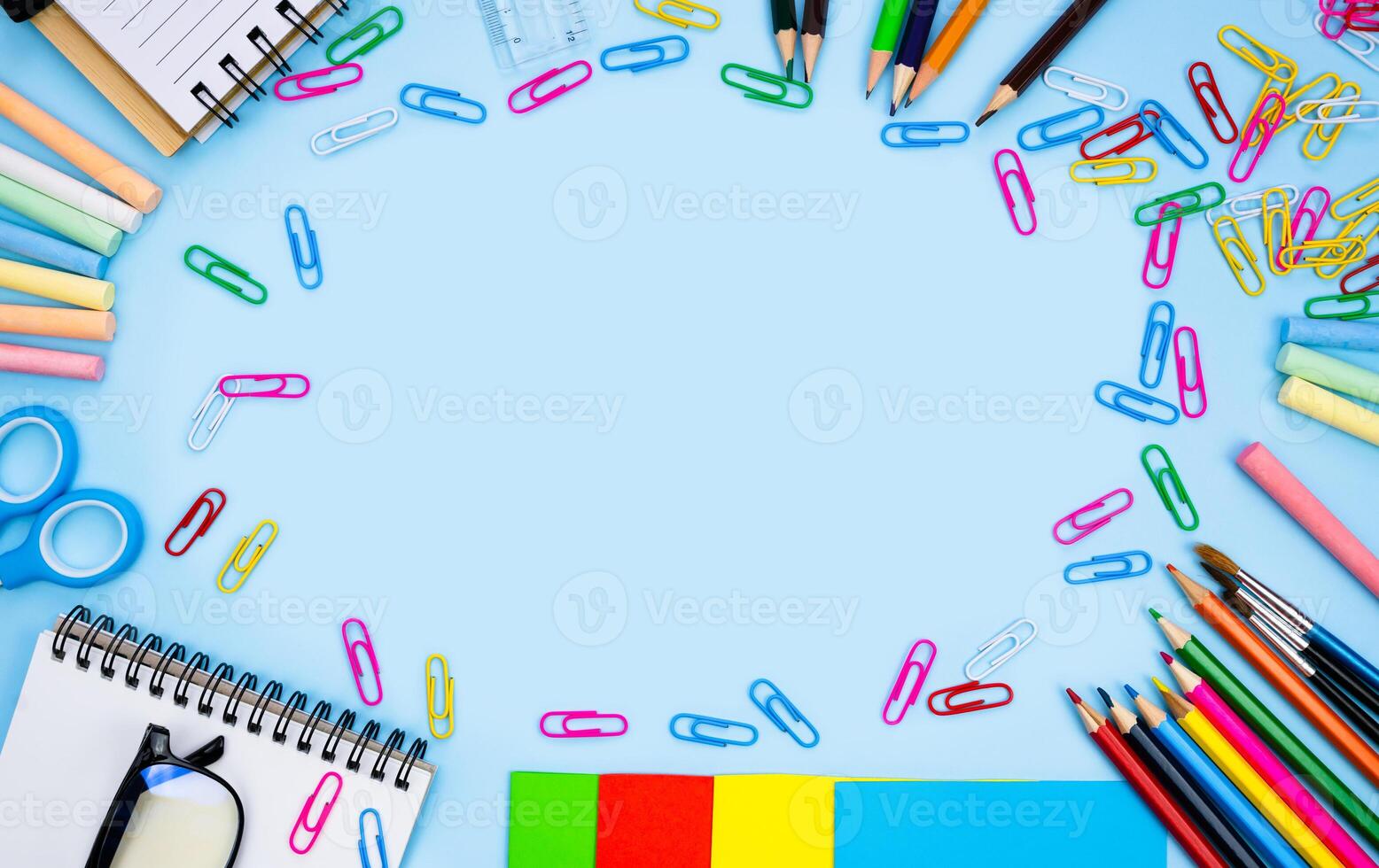 Colorful school stationery lie in the shape of a frame on blue background. Back to school. Flatlay composition. Top view. Copy space. photo