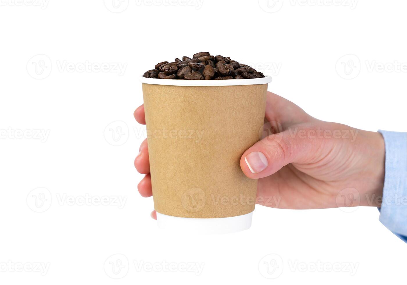 A woman's hand holds a disposable paper cup with coffee beans isolated on white background. Coffee to go. photo