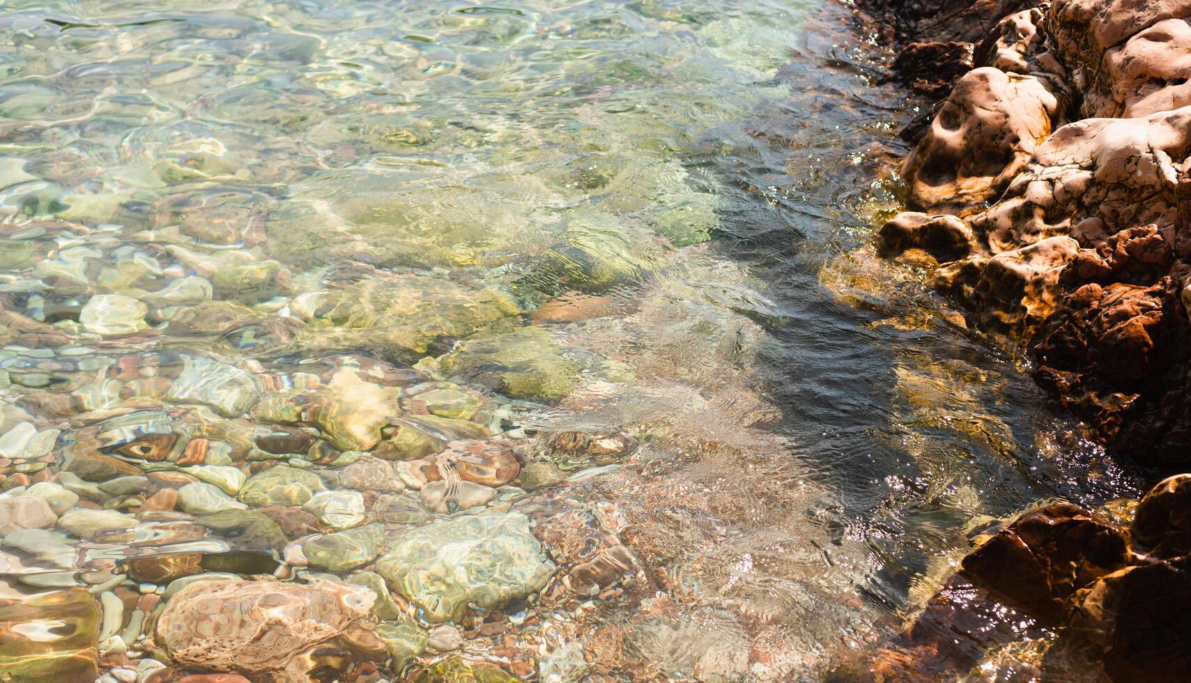 Sea stones in the sea at summer sunny day. Nautical background of pebbles. Seascape. Selective focus. photo