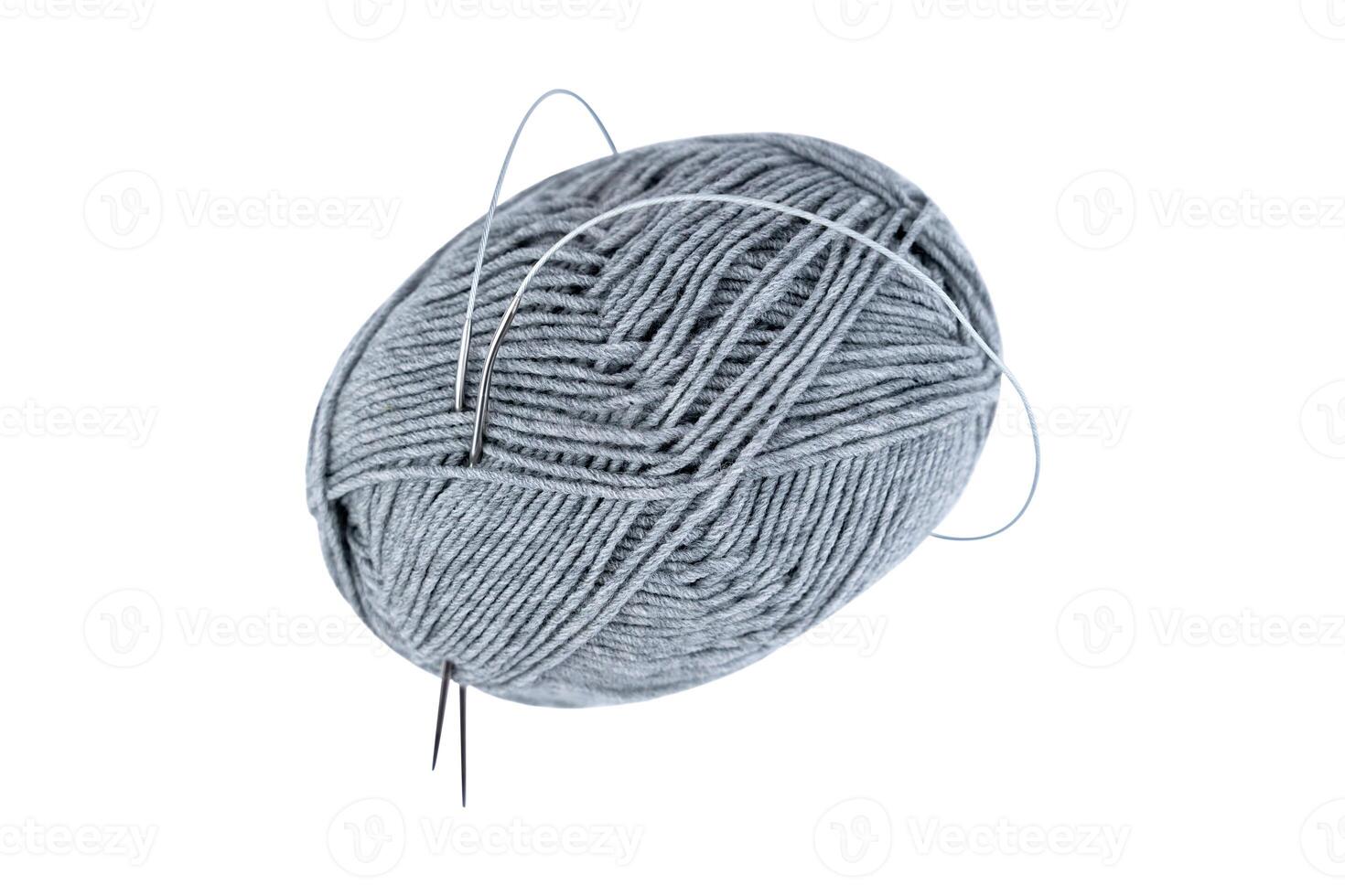 Skein of grey yarn with knitting needles isolated on white background. Top view. photo