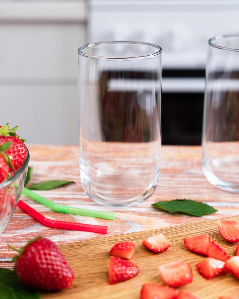 Empty glasses on the table in the kitchen for strawberry lemonade. Making lemonade with strawberries. Selective focus. photo
