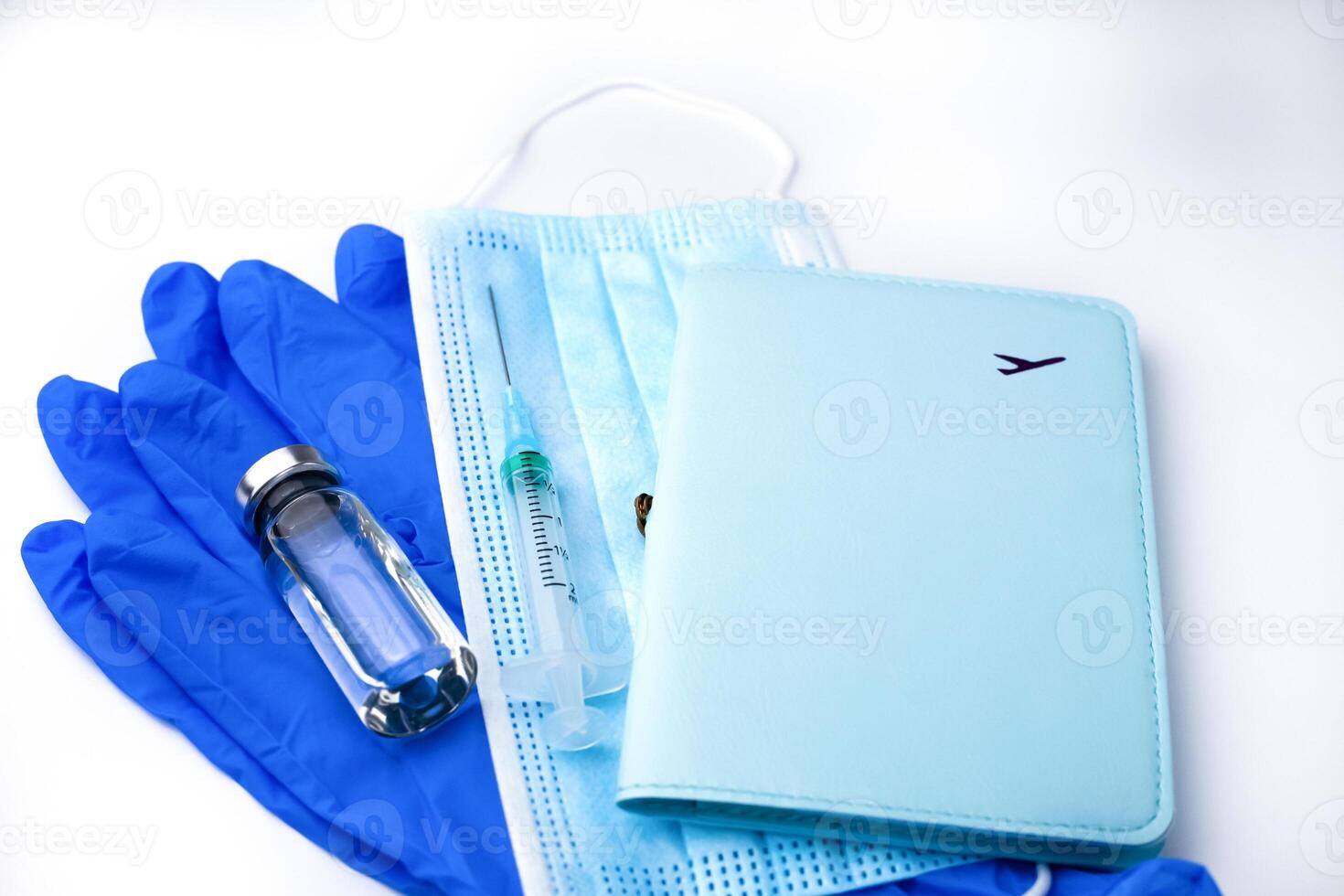 Safe travel concept. Passport and vaccination kit vaccine, syringe, mask and protective gloves on a white background. Influenza and coronavirus vaccination. Close-up. photo