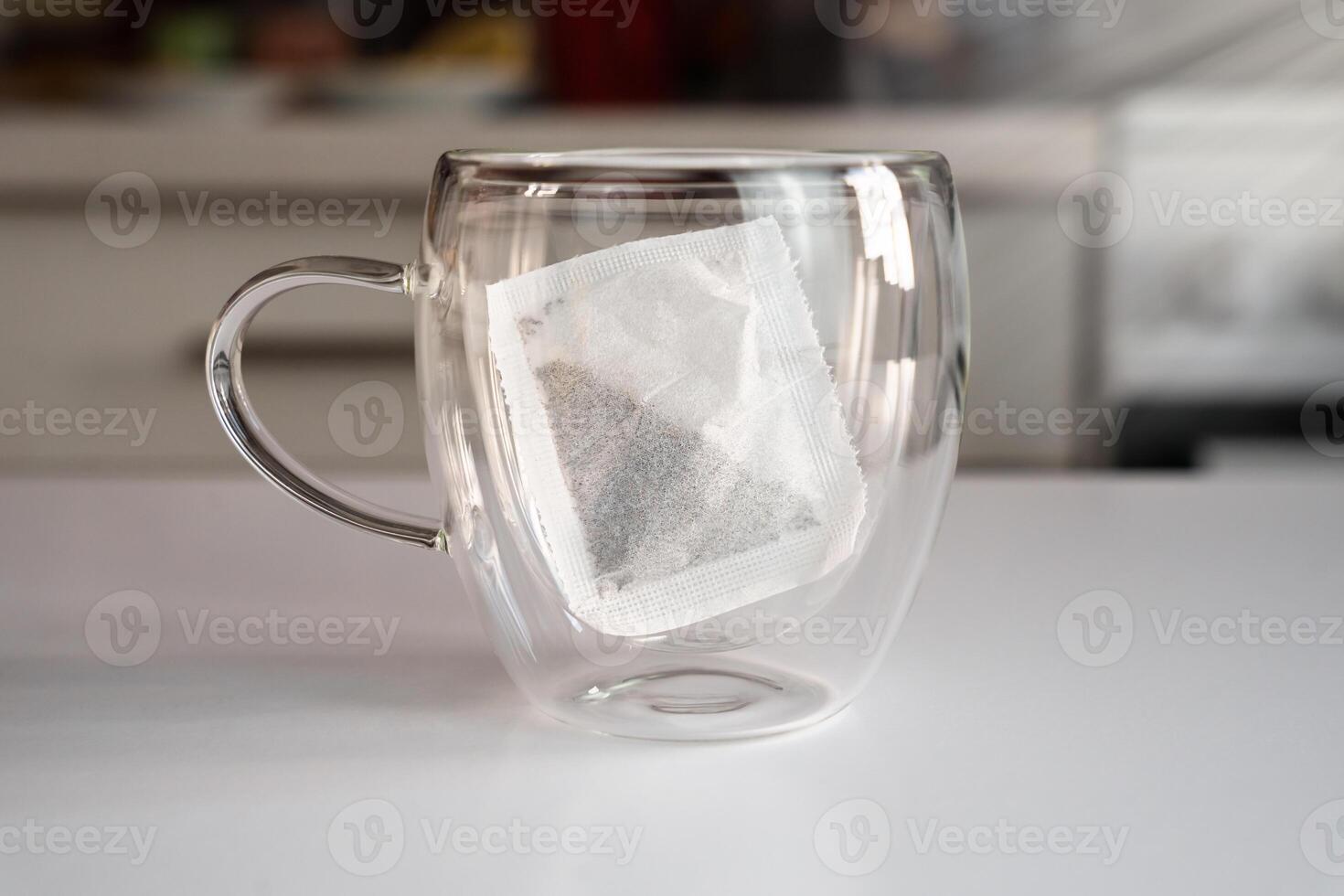 Empty mug and tea bag on the table at the kitchen. Tea drinking concept. Close-up. Selective focus. photo
