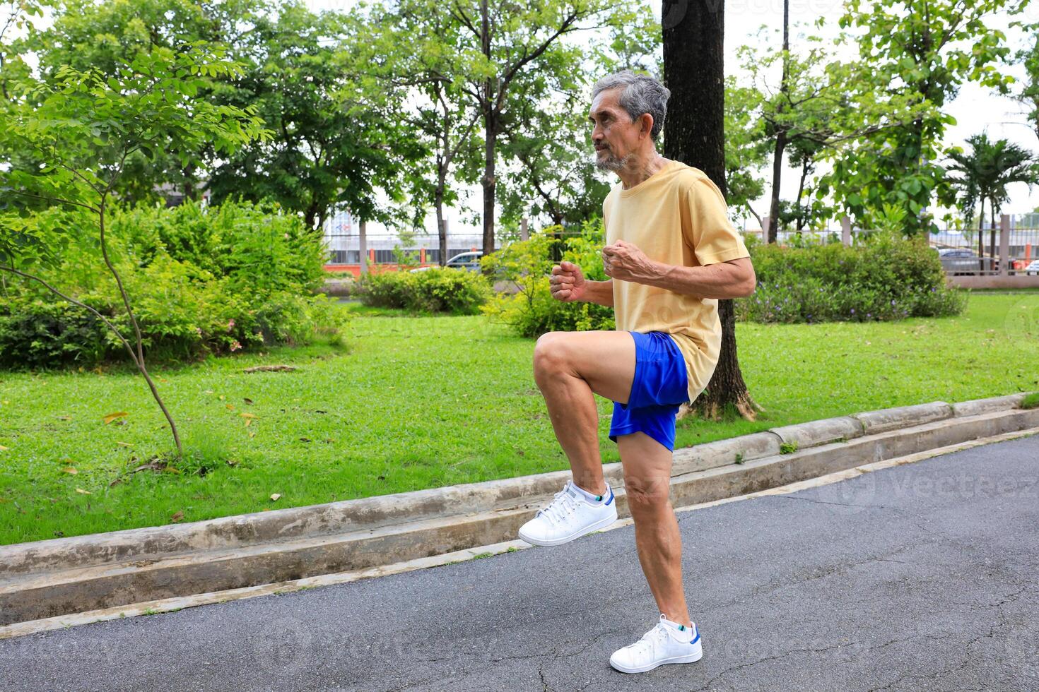 Senior Asian man is stretching his leg muscle during warm up exercise work out in the morning at public park for healthy and longevity photo