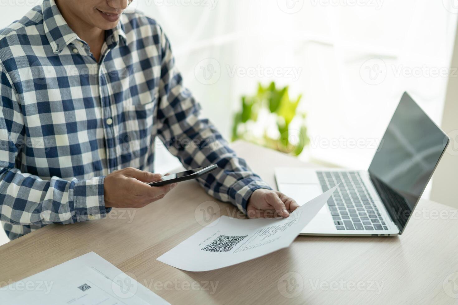 business man use phone to scan barcode or QR codes to pay credit card bill after receiving document invoice online. payment, receive, paying electricity, digital payments without money, technology photo