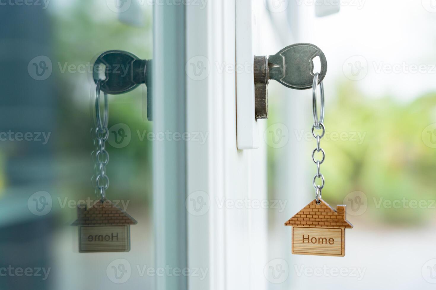 Landlord key for unlocking house is plugged into the door. Second hand house for rent and sale. keychain is blowing in the wind. mortgage for new home, buy, sell, renovate, investment, owner, estate photo