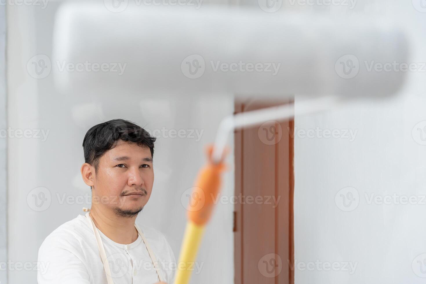 painter man, brush in hand for products to restore and paint the wall, indoor the building site of a house, wall during painting, renovation, painting, contractor, Architect, construction worker photo