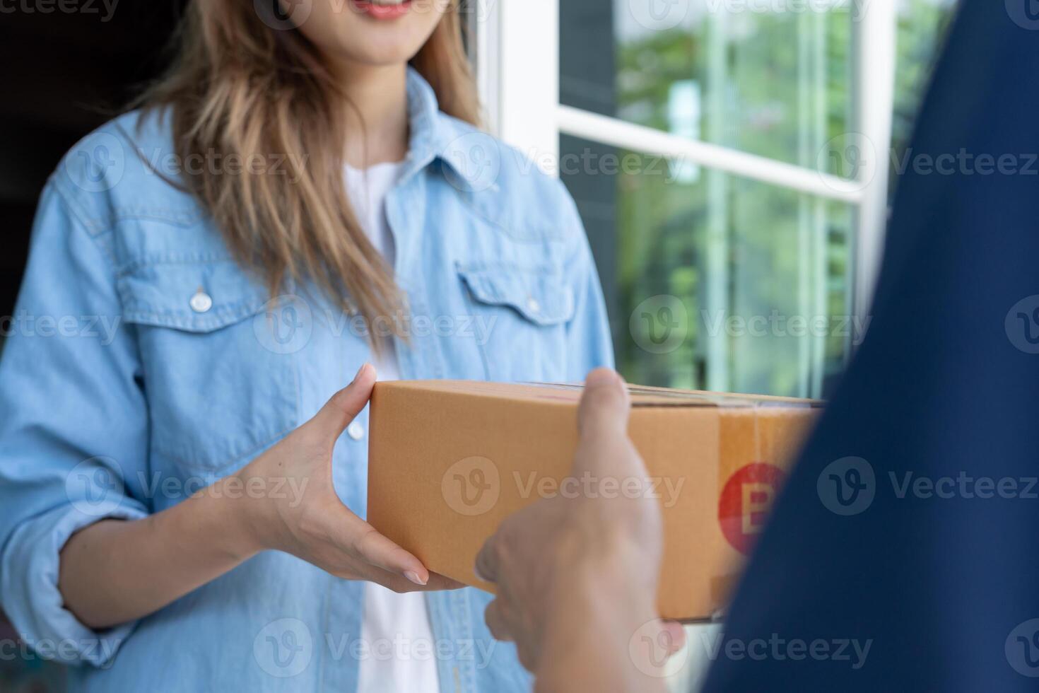 Happy smiling woman receives boxes parcel from courier in front house. Delivery man send deliver express. online shopping, paper containers, takeaway, postman, delivery service, packages photo