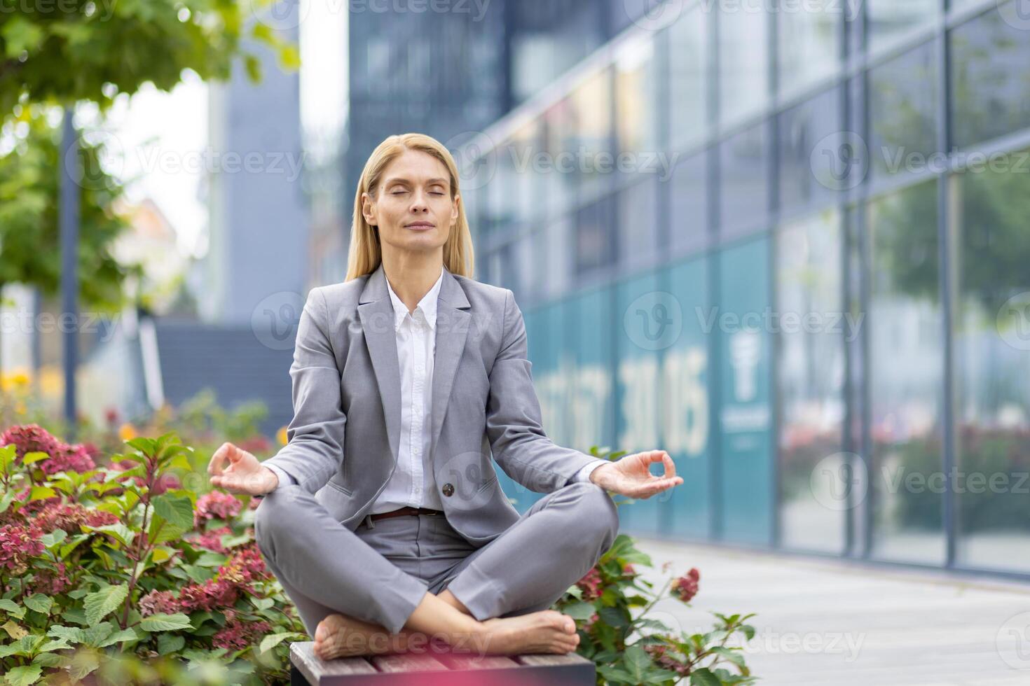 Professional businesswoman practicing yoga and meditation outdoors in the city to relieve stress and improve focus. photo