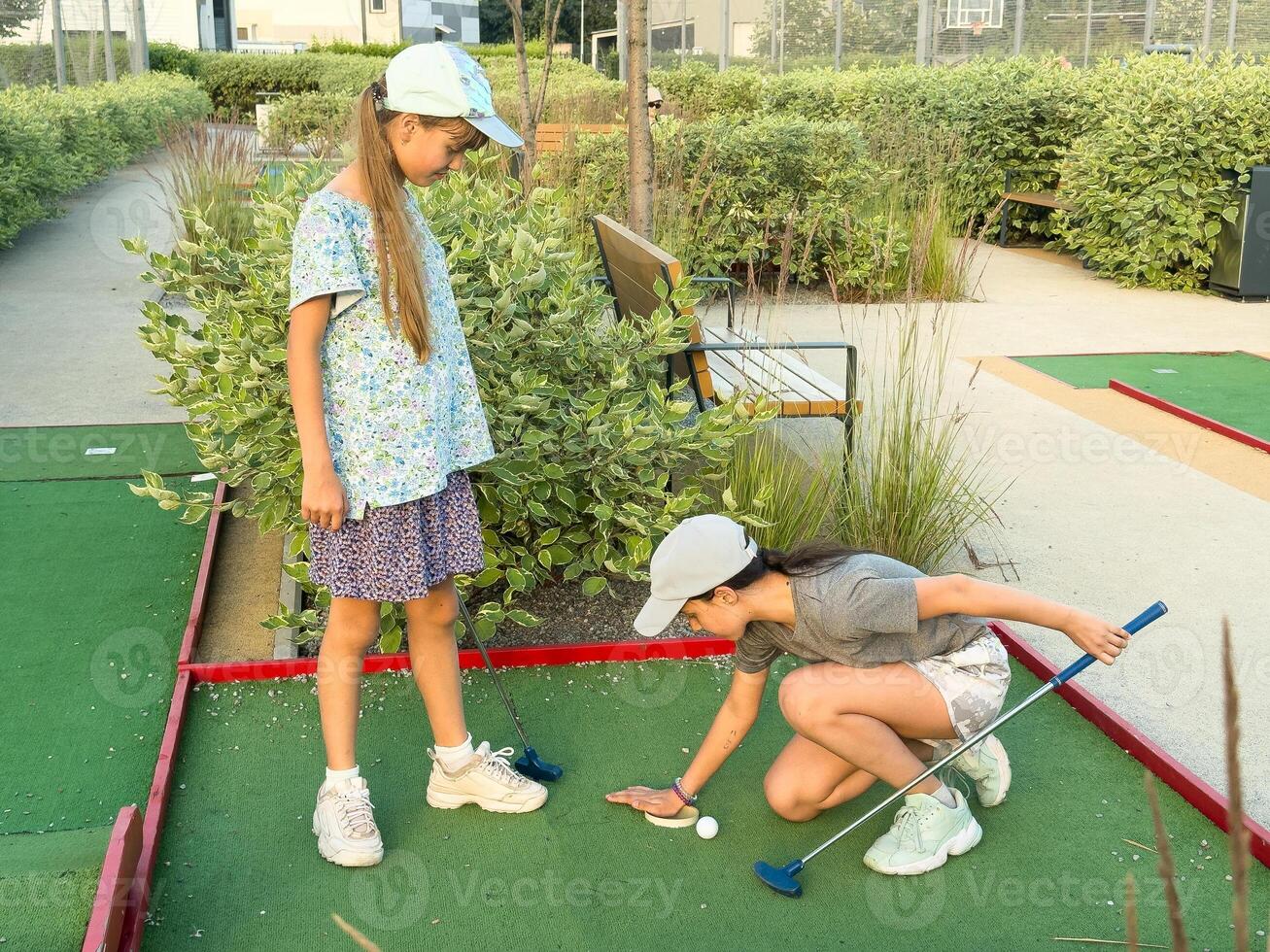children practice playing mini golf photo