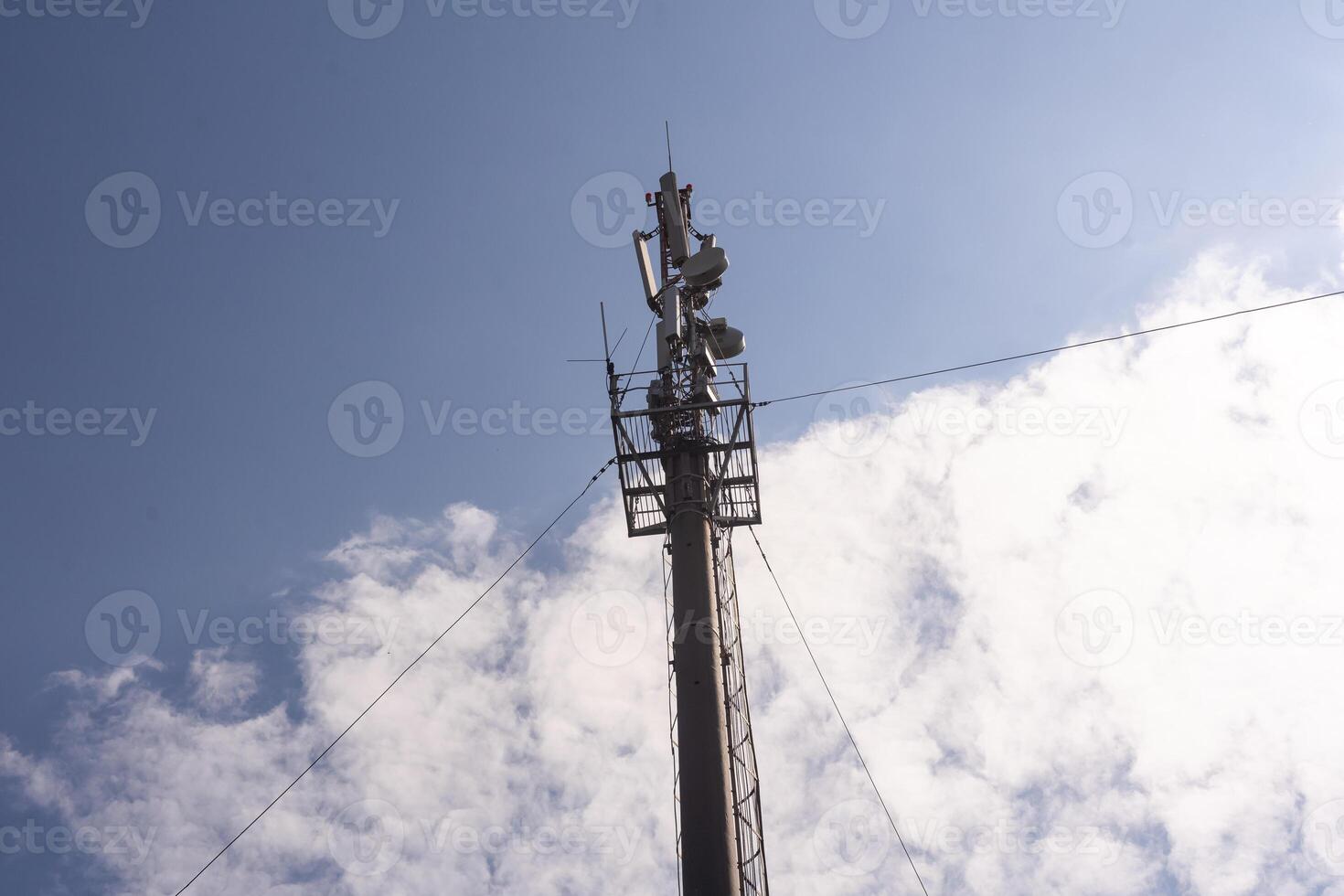 Telecommunication tower of 4G and 5G cellular. Macro Base Station. 5G radio network telecommunication equipment with radio modules and smart antennas mounted on a metal on cloulds sky background.. photo