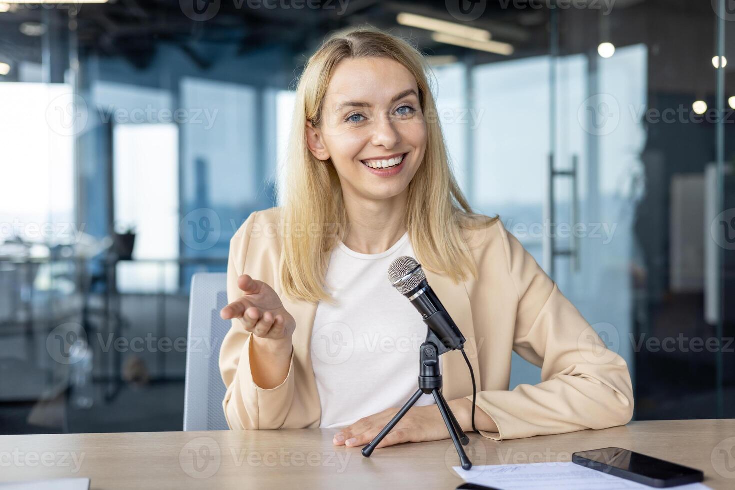 Confident professional woman speaking into a microphone during a live chat meeting. Engaged and friendly, she communicates effectively in a modern office setting. photo