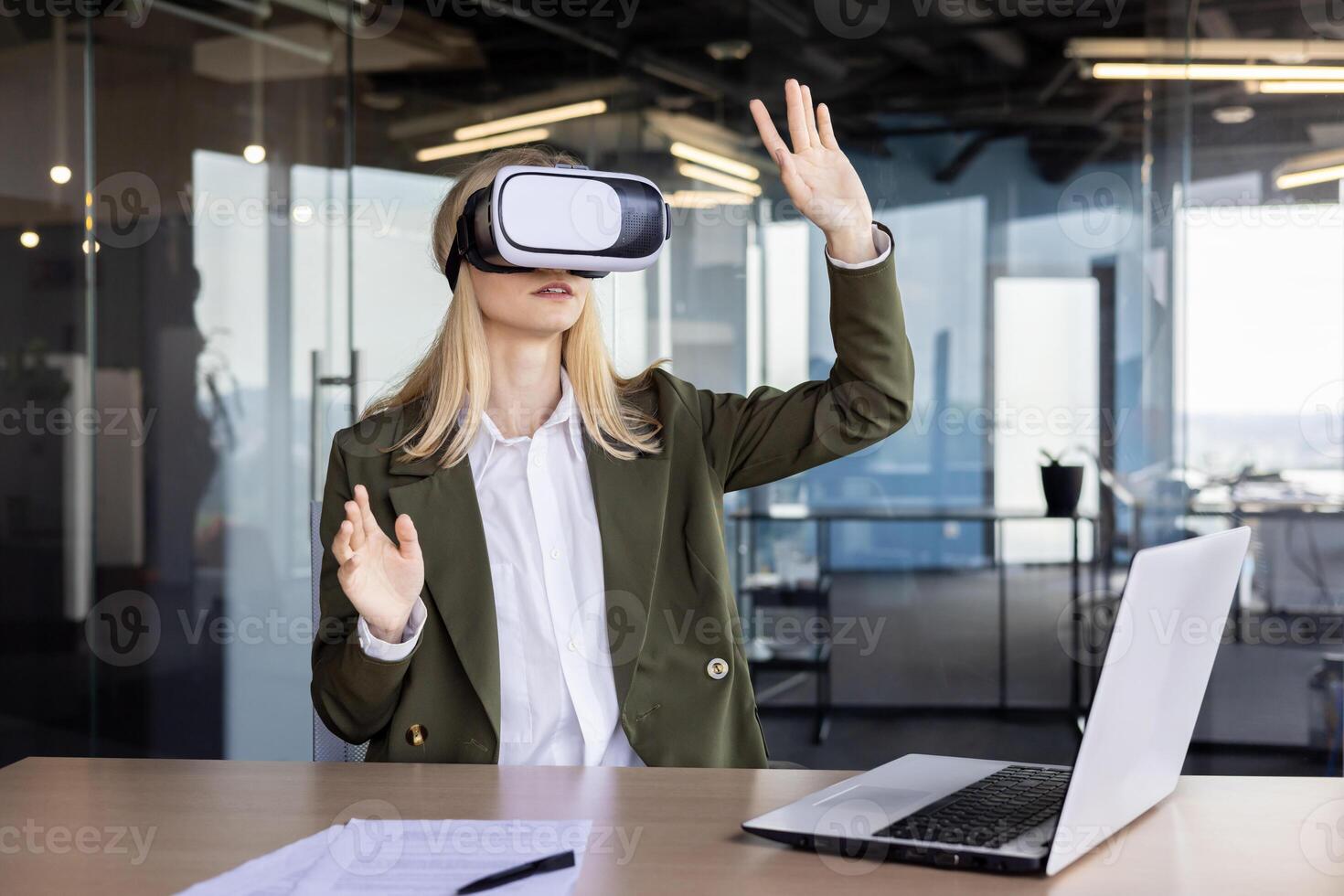 A professional businesswoman using a virtual reality headset at her desk in a contemporary office setting, demonstrating the integration of advanced technology in the workplace. photo