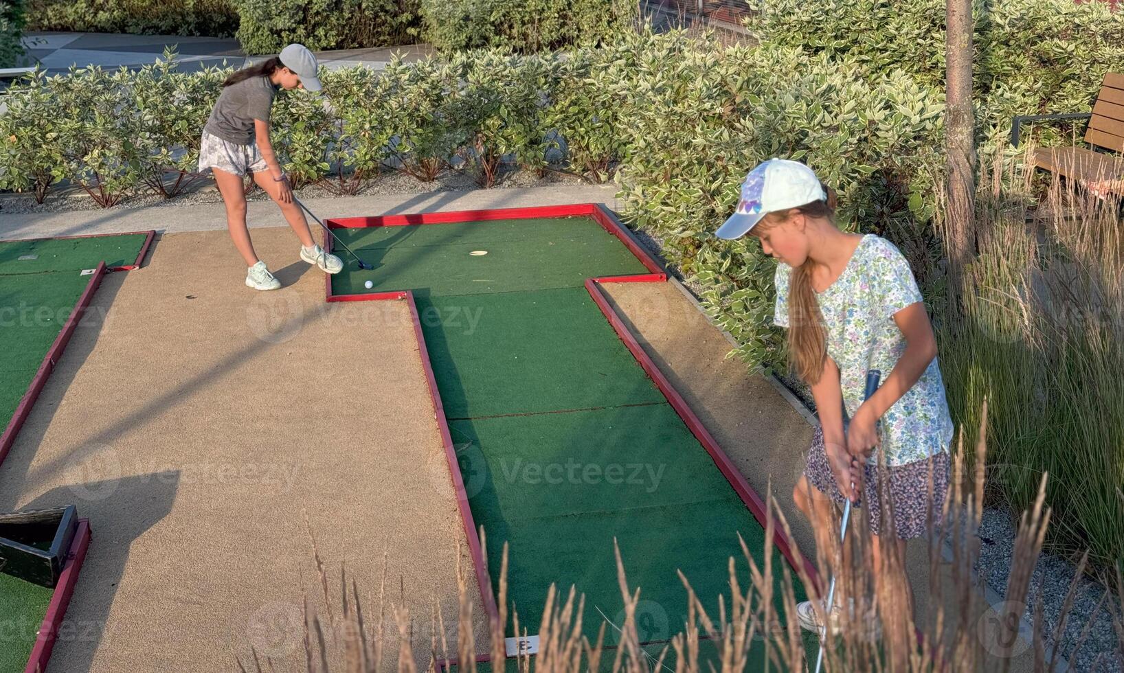 teenage girls play mini golf photo