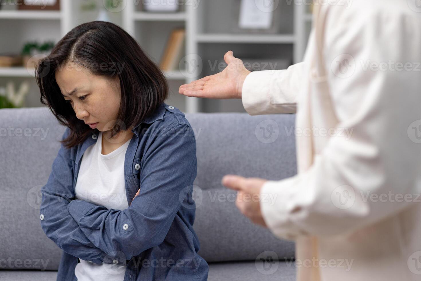 A woman appears upset and stressed while having an argument with her partner at home, conveying emotions of tension and conflict. photo