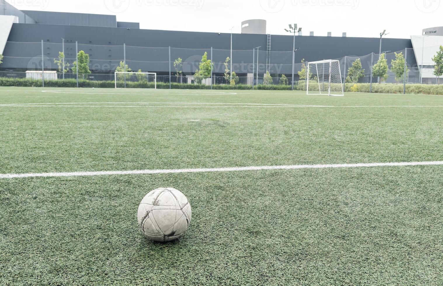 Green grass and white border lines on football ground. Soccer field on artificial turf. Artificial green grass texture. Artificial football field in an open stadium photo