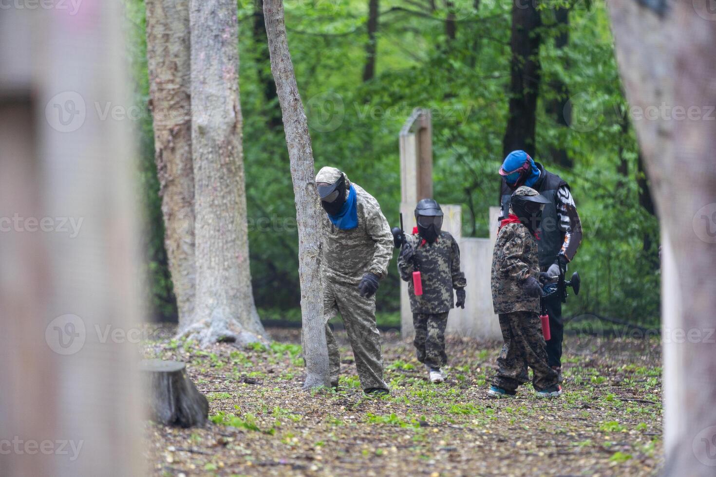 children playing paintball in the forest photo