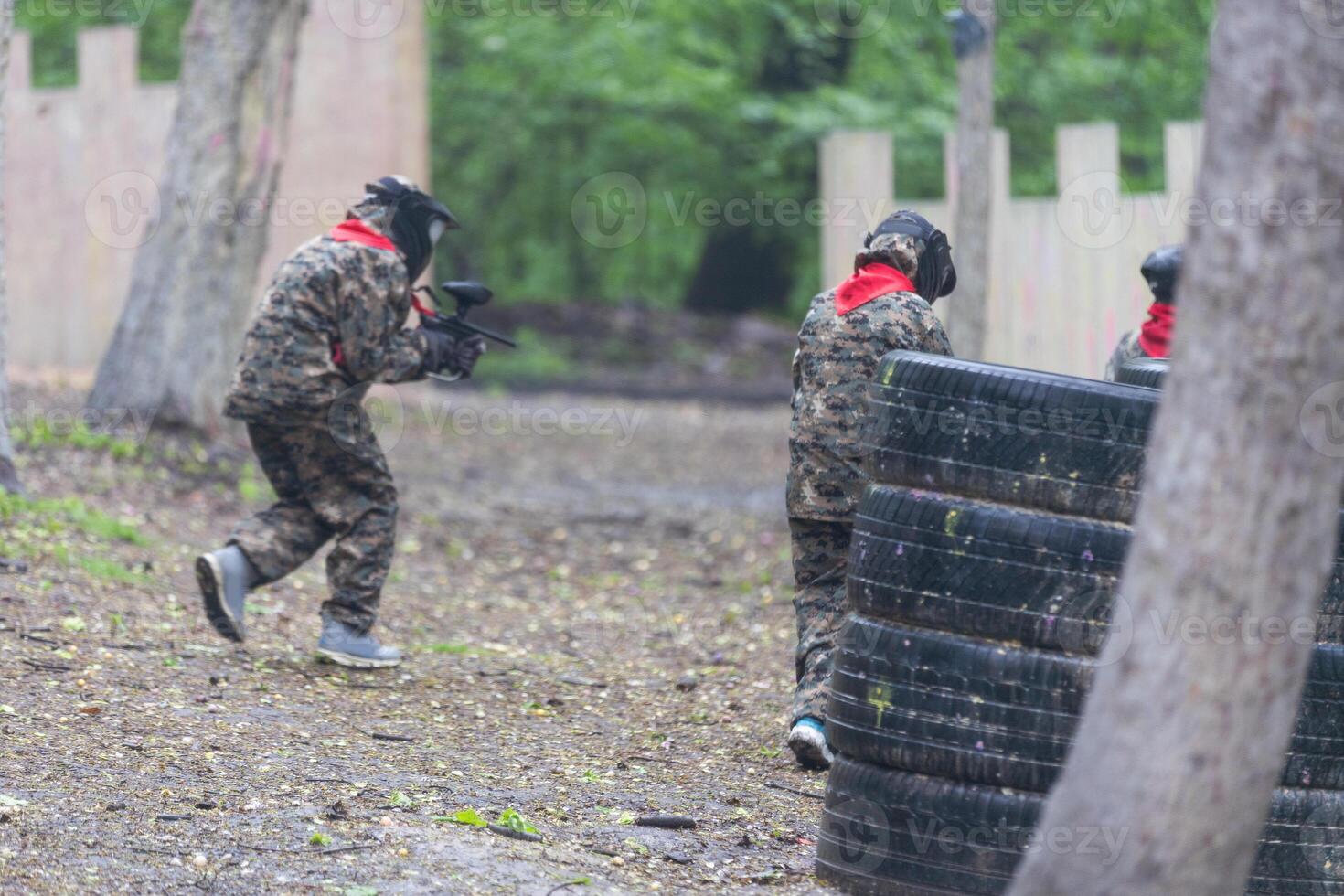 children playing paintball in the forest photo
