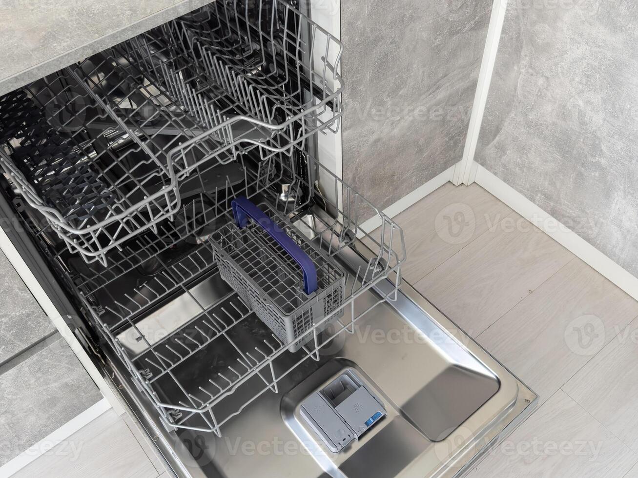 Open clean empty dishwasher in kitchen. Home appliance photo