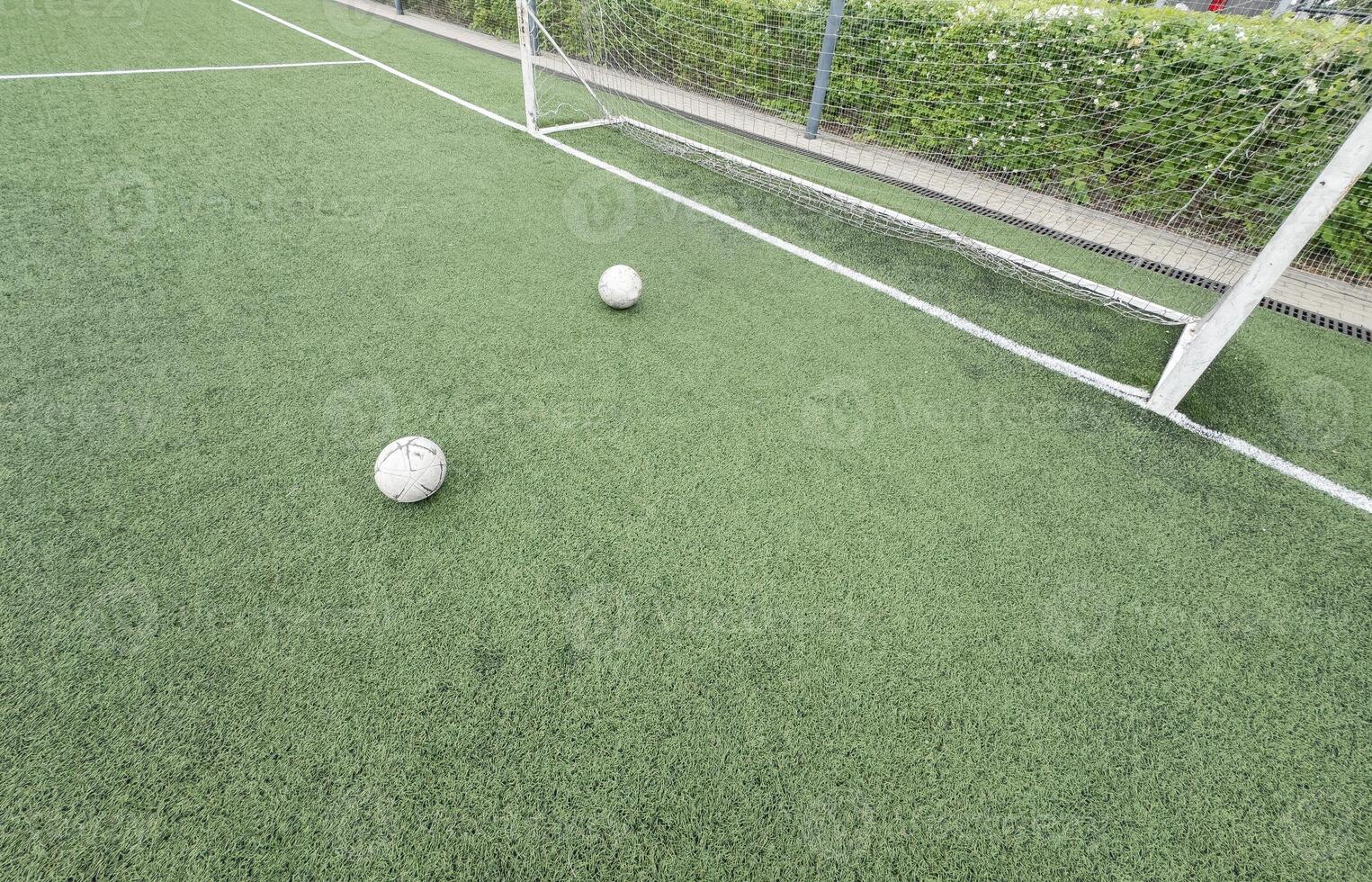 Green grass and white border lines on football ground. Soccer field on artificial turf. Artificial green grass texture. Artificial football field in an open stadium photo