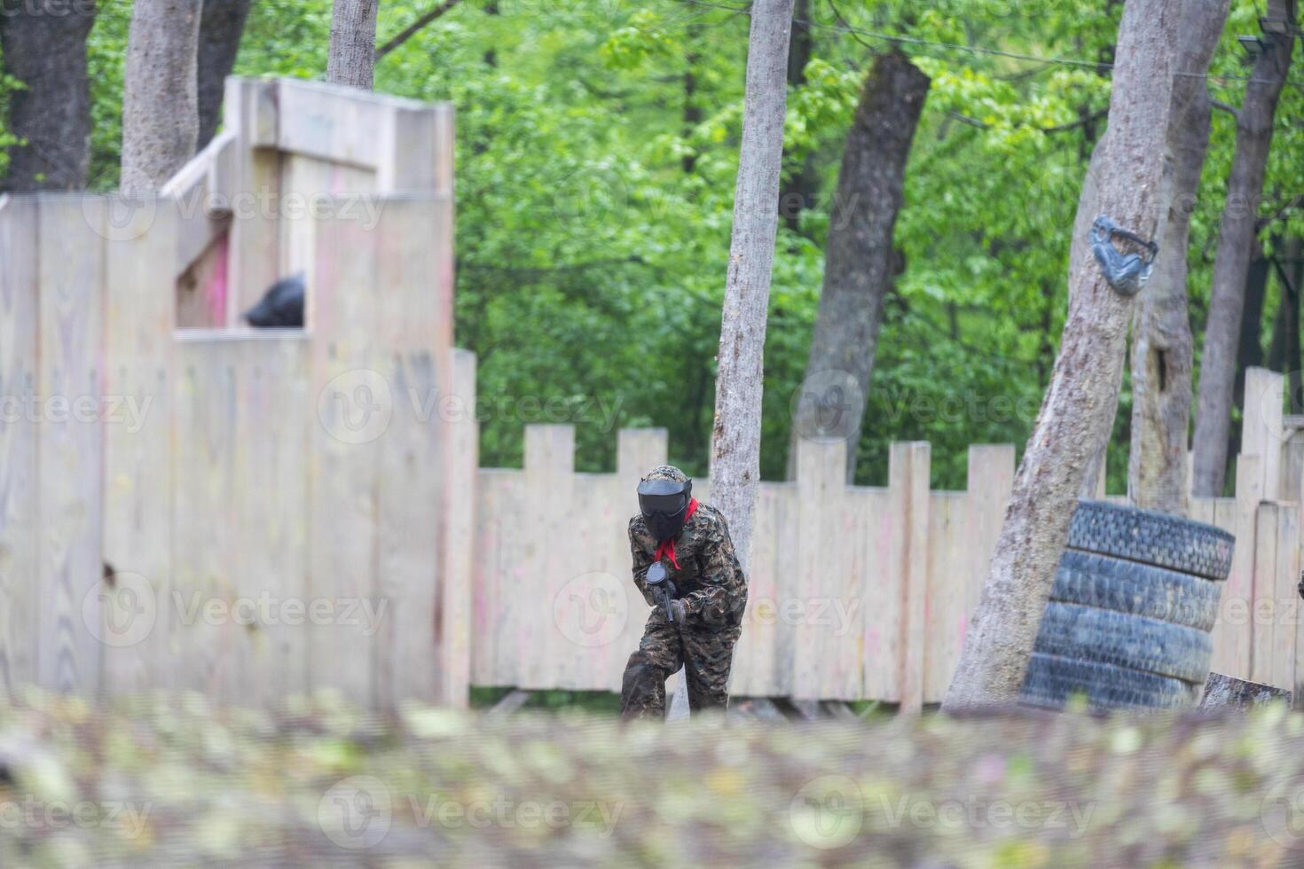 children playing paintball in the forest photo
