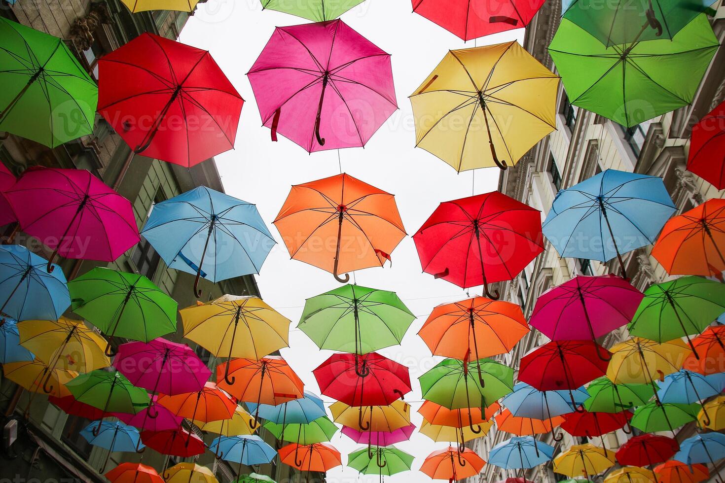Multicolored, rainbow, umbrellas hung over the street. photo