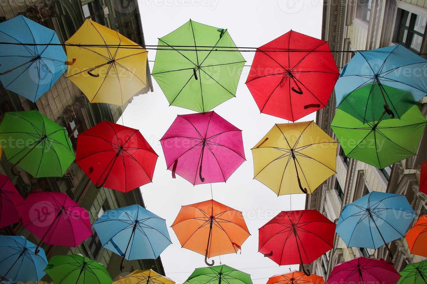 Multicolored, rainbow, umbrellas hung over the street. photo