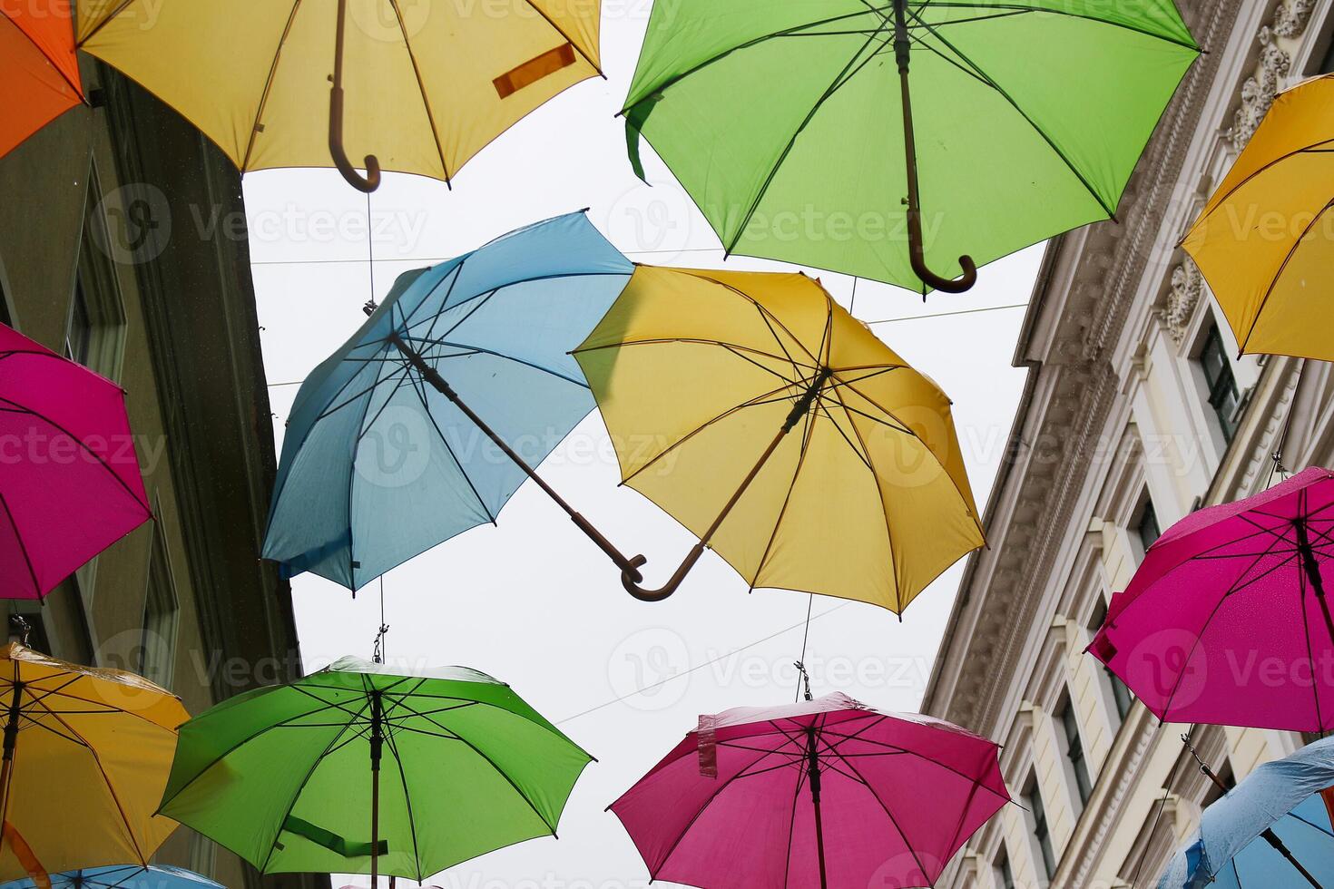 Multicolored, rainbow, umbrellas hung over the street. photo