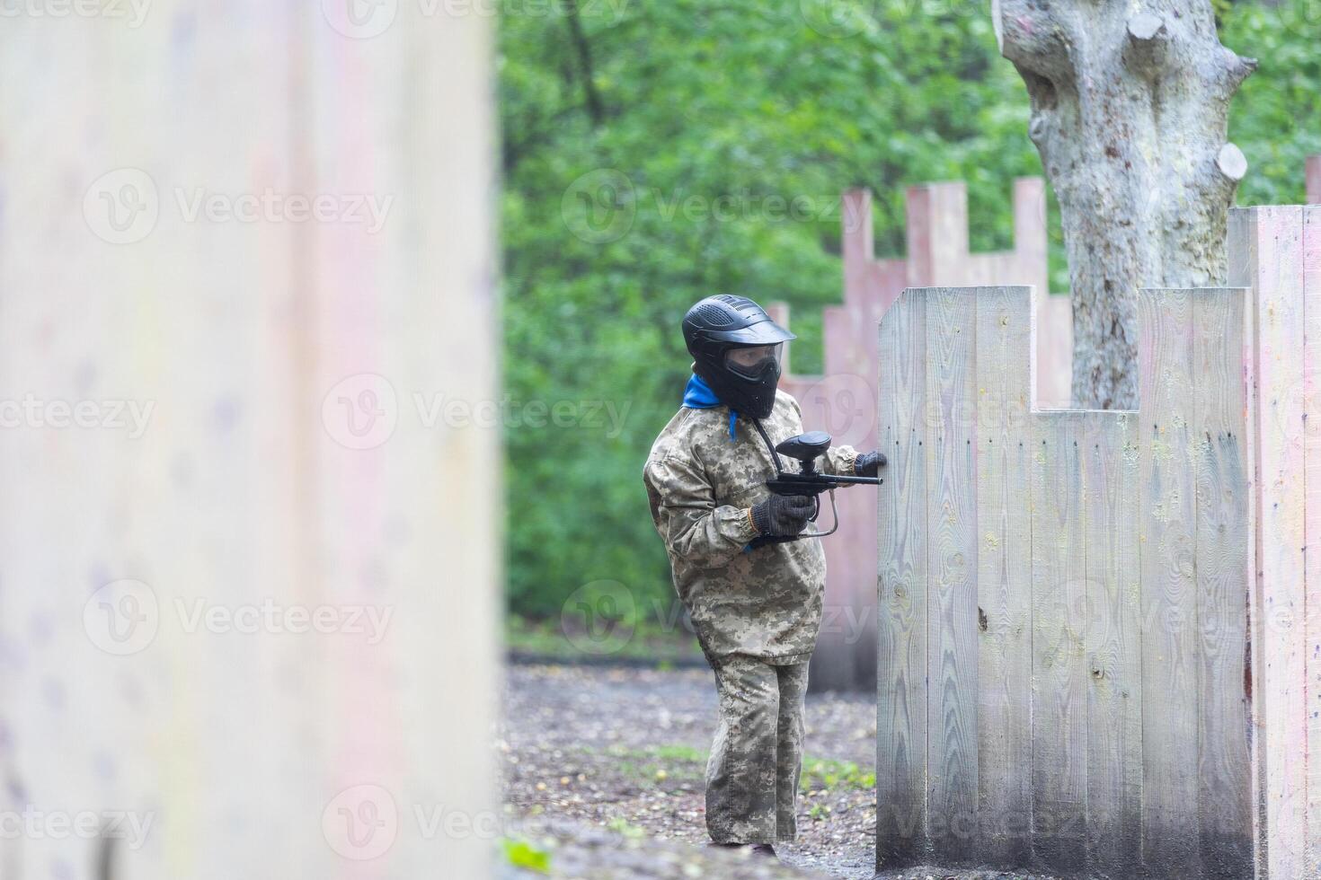 children playing paintball in the forest photo