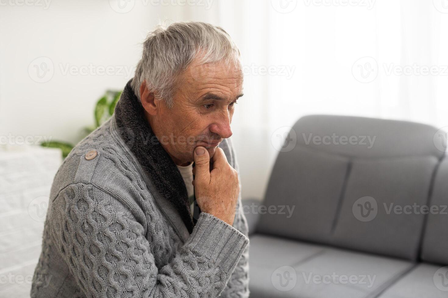 Elderly man grieves at home. Single people. Man upset headache photo