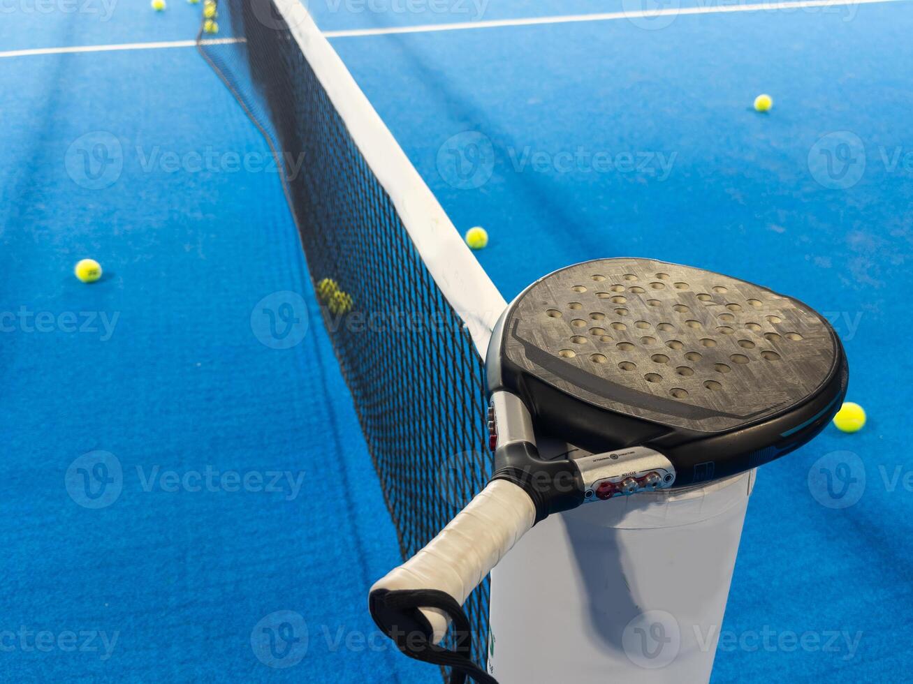 paddle tennis racket and balls on the blue paddle court photo