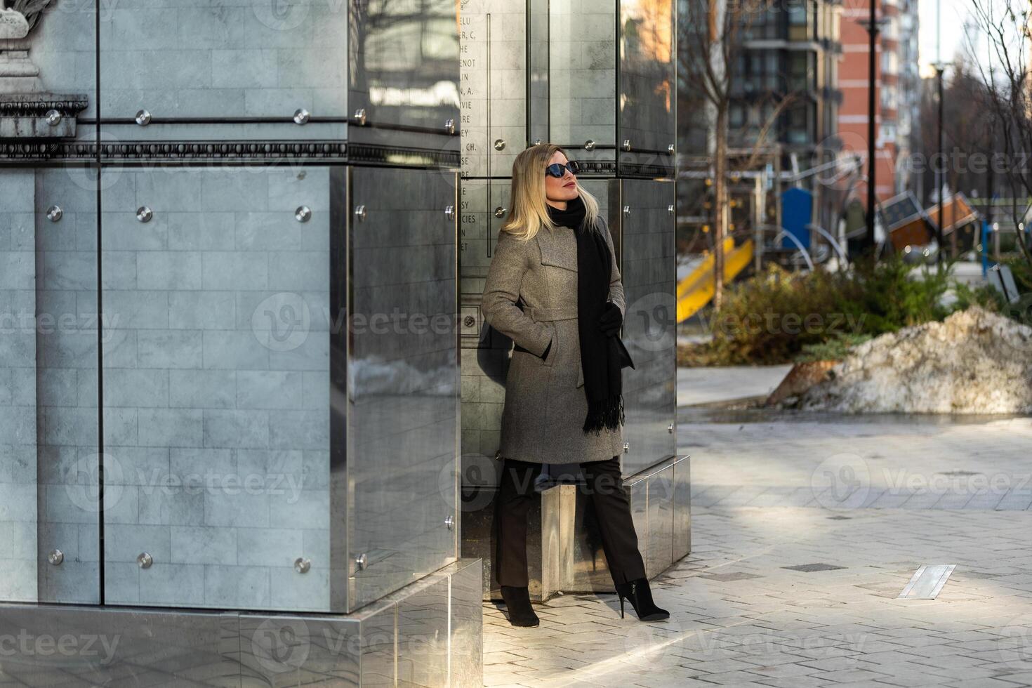 Beautiful girl in a ccoat and scarf and black glasses photo