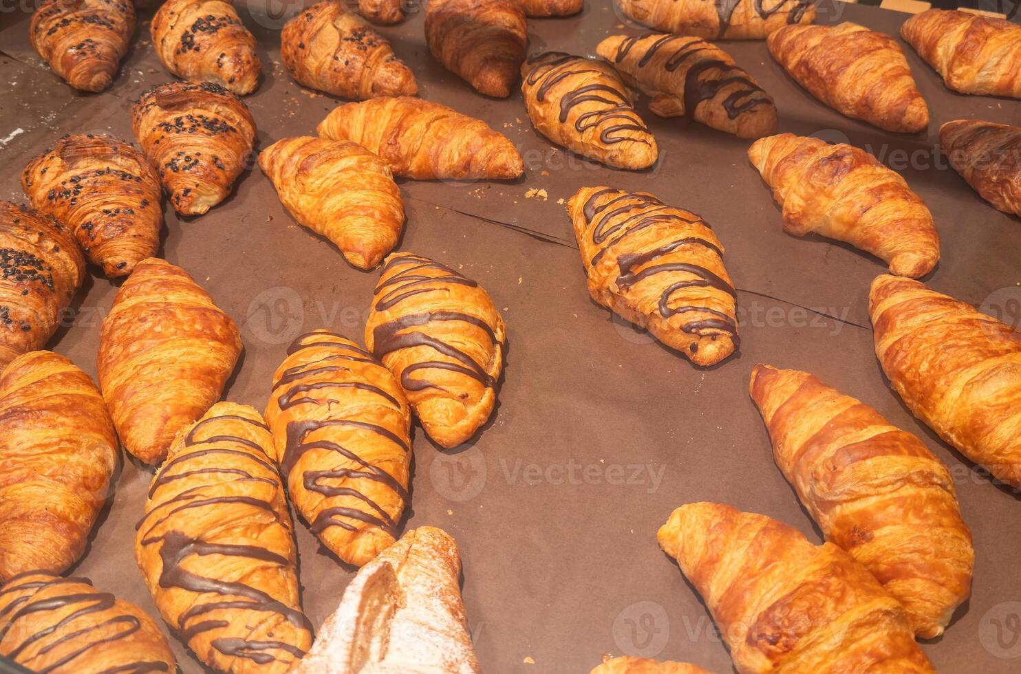 Close up freshly baked croissants in a orange crate. photo