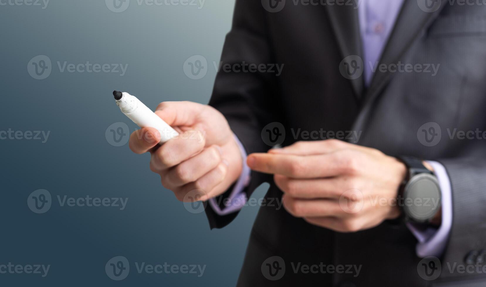 Businessman with a marker on grey background photo