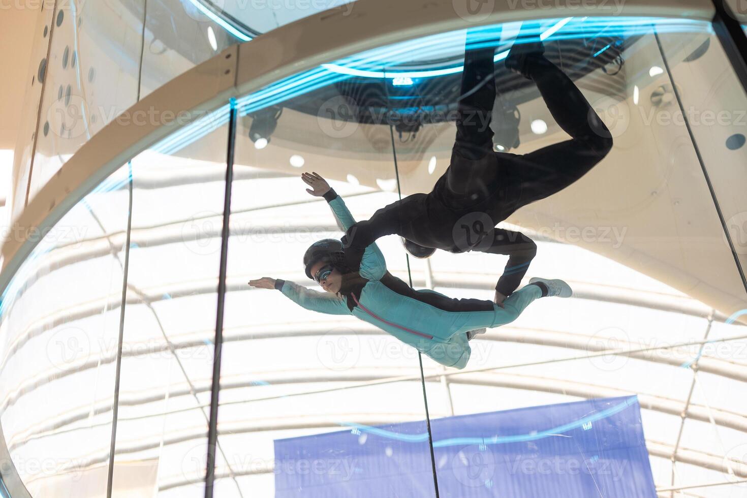 A teenage girl and an instructor climb up in an air tube photo