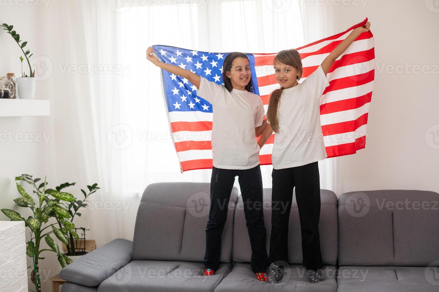 Two sisters with American flag on grey background photo